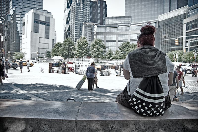 Woman sitting on bench at Columbus Circle.