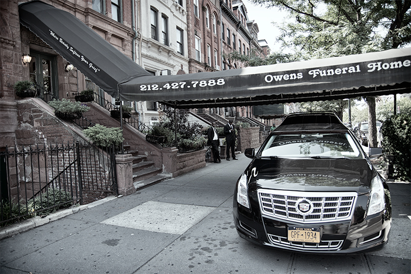 Awning and hearse in front of funeral home.