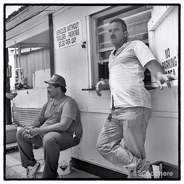 Men in front of signs for marina parking.
