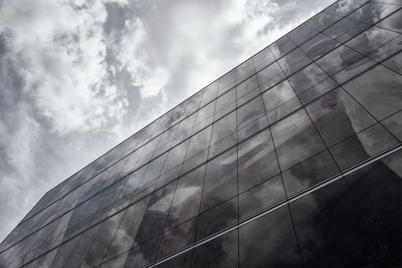 Facade of hospital with clouds and reflections.