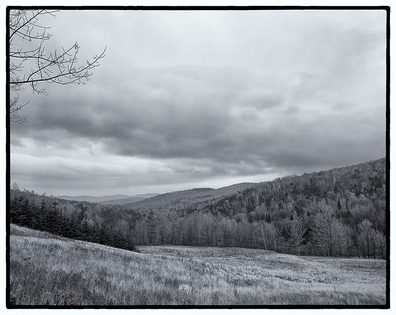 Hills and valley against cloudy sky